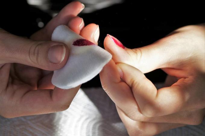 Gros plan des mains, enlever le vernis à ongles.