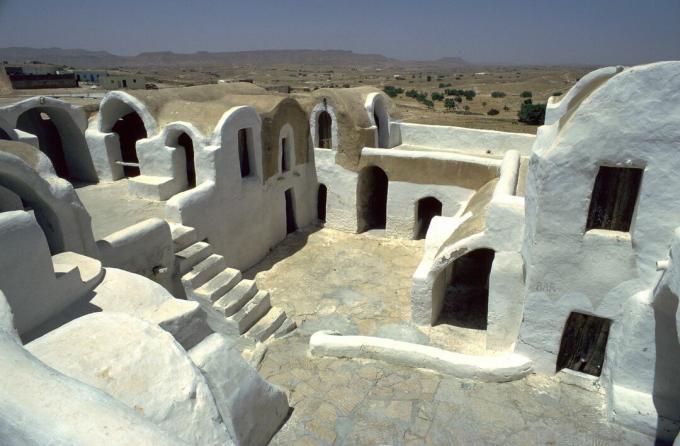 structures en terre blanche construites sous la surface de la terre mais ouvertes à l'air avec de multiples fenêtres, portes et escaliers