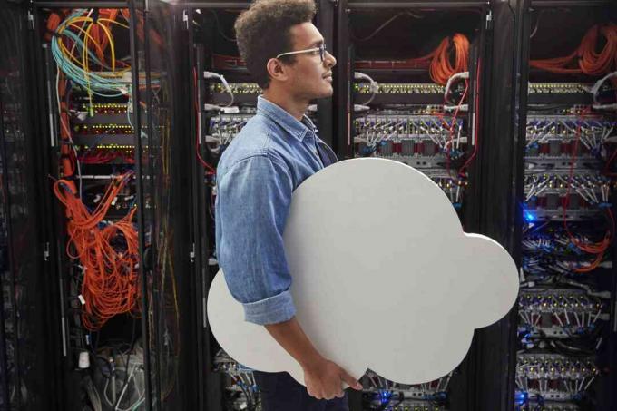 Technicien informatique masculin transportant le cloud dans la salle des serveurs, le cloud computing