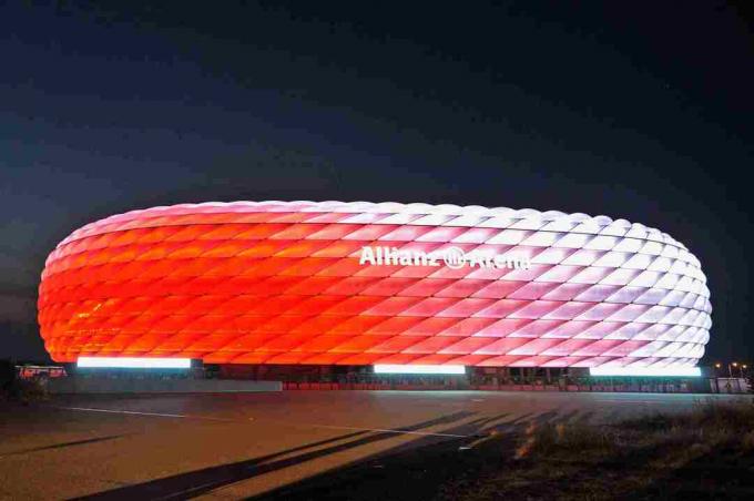 blanc de jour, l'extérieur sculpté de l'Allianz Arena brille de rouge la nuit