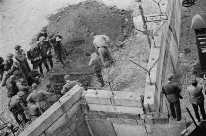 Un groupe de soldats est-allemands enquête sur un tunnel creusé sous le mur de Berlin.