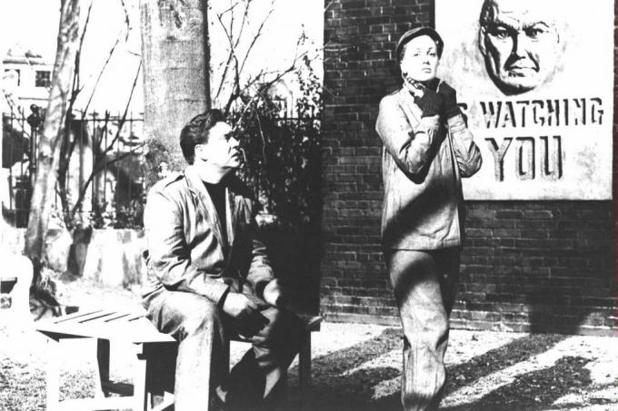 Les acteurs Edmond O'Brien et Jan Sterling avec une affiche de Big Brother derrière eux dans une image tirée de la version cinématographique du roman de George Orwell «1984».