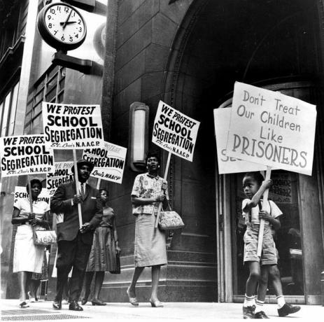 Des manifestants, dont un jeune garçon, ont fait du piquetage devant le bureau d'une commission scolaire pour protester contre la ségrégation.