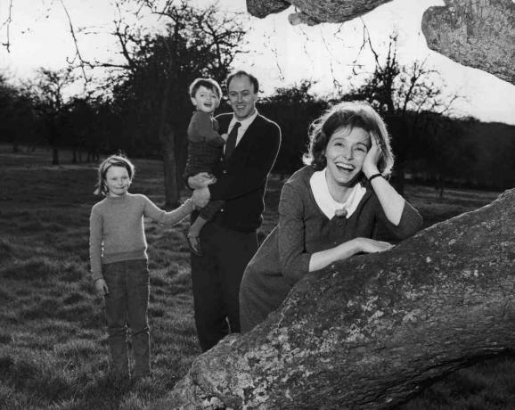 Photo en noir et blanc de Roald Dahl tenant ses enfants; sa femme Patricia Neal s'appuie sur un arbre