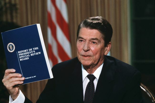Le président Ronald Reagan tenant une copie du rapport de la Commission Tower sur le scandale Iran-Contra