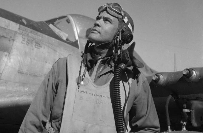 Benjamin O. Davis dans une combinaison de vol et un casque debout devant un chasseur P-51 Mustang.