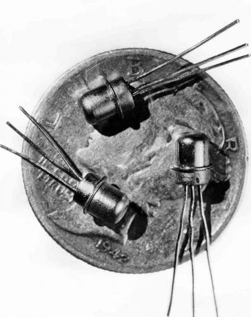 Photo datée de 1956 de trois transistors M-1 miniatures vus sur la face d'un dix sous