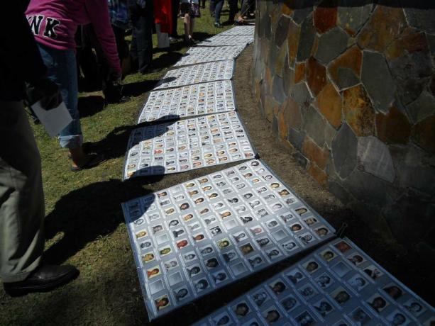 Portraits commémoratifs des victimes du massacre de Jonestown exposés au sol.