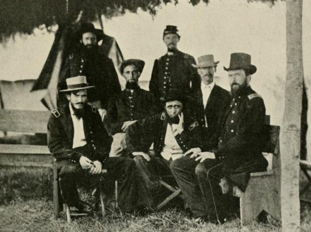 Benjamin H. Grierson assis en uniforme bleu de l'armée de l'Union entouré de ses officiers d'état-major.