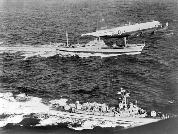 Le cargo soviétique Anosov, à l'arrière, escorté par un avion de la Marine et le destroyer USS Barry, alors qu'il quitte Cuba pendant la crise des missiles de Cuba en 1962.