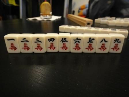 Le costume de caractère d'un ensemble de carreaux de Mahjong assis sur une table.