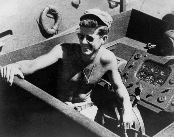 John F. Kennedy, torse nu et portant des lunettes de soleil à la tête du PT-109.