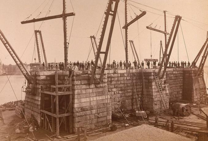 Photographie d'une tour du pont de Brooklyn en construction.
