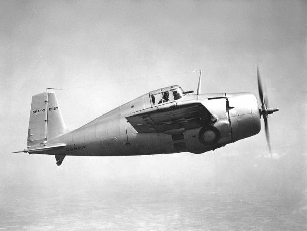 Grumman XF4F-3 Wildcat volant de gauche à droite, finition aluminium argenté, pilote regardant dehors.