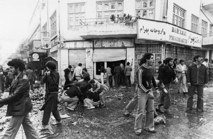 4 novembre 1978 Des gens se rassemblent autour d'une victime tandis que d'autres pillent un magasin après une émeute à Téhéran