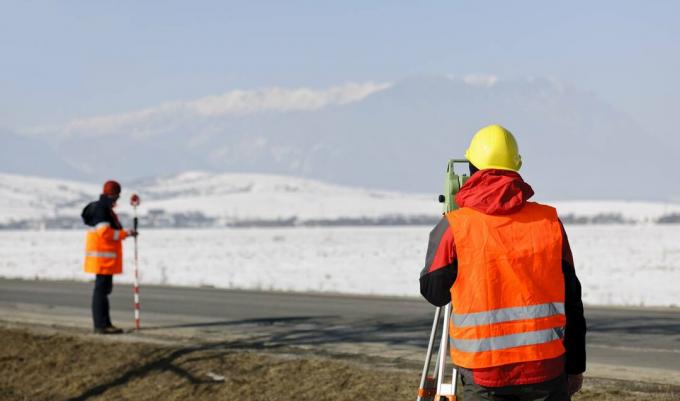 arpenteur-géomètre travaillant dans le champ d'hiver