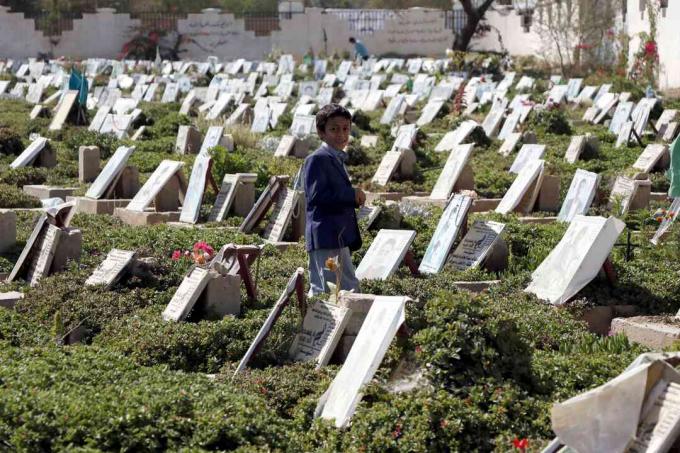 Un enfant marche parmi les tombes de personnes qui ont été tuées pendant la guerre en cours dans un cimetière de Sanaa, au Yémen.