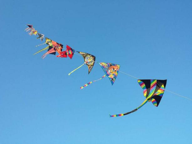 Cerfs-volants en papier coloré contre un ciel bleu sans nuages.