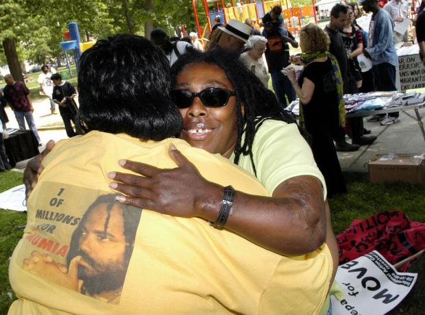 Ramona Africa (R), la seule survivante de la tragédie MOVE de 1985, embrasse Denise Garner (L) lors d'une marche commémorative en 2005